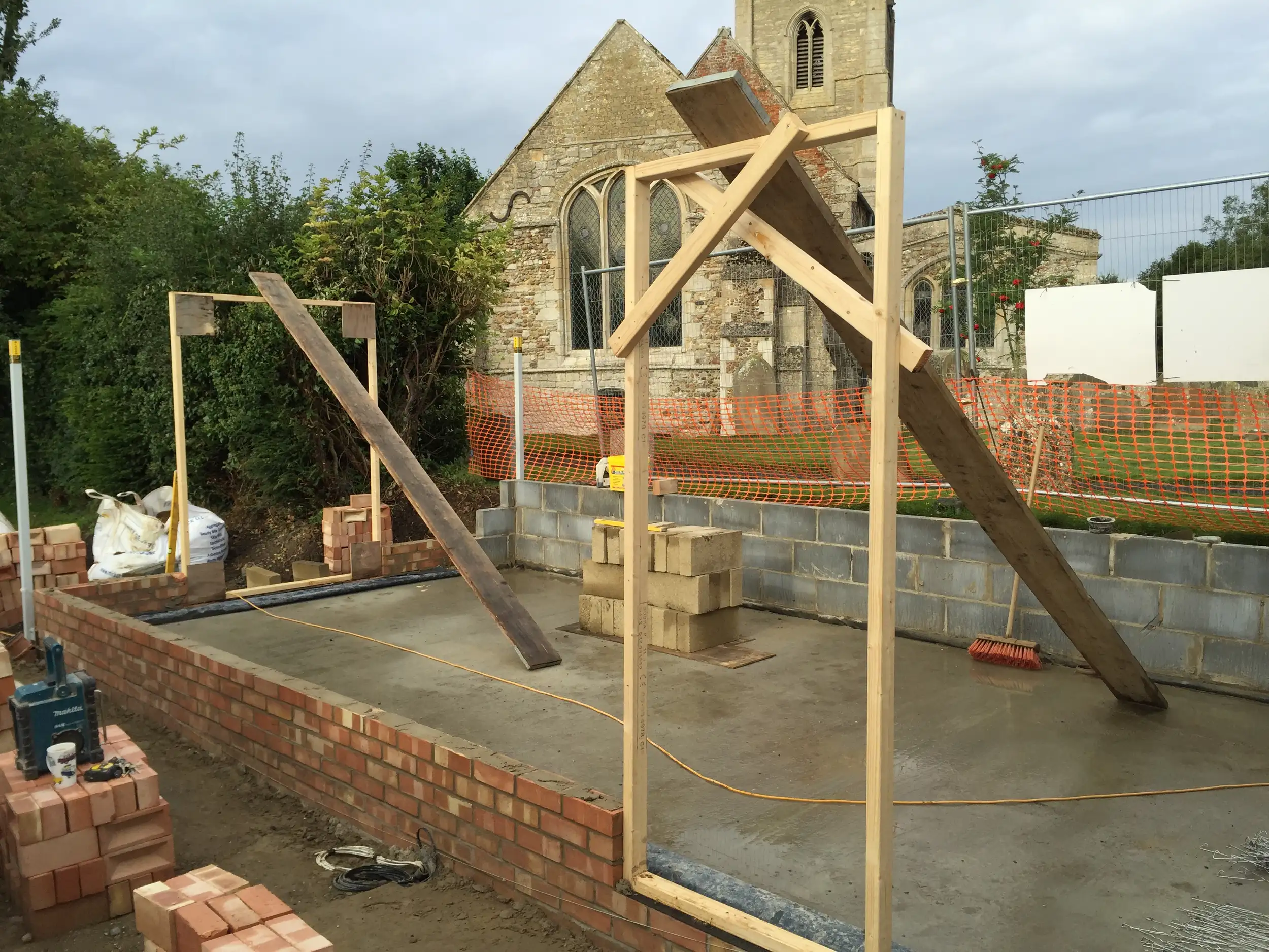 Oak frame and stonework going up beside a church